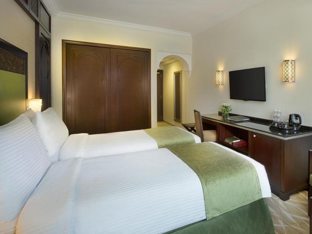 غرفة كلاسيكية بسريرين مطلة على المدينة.