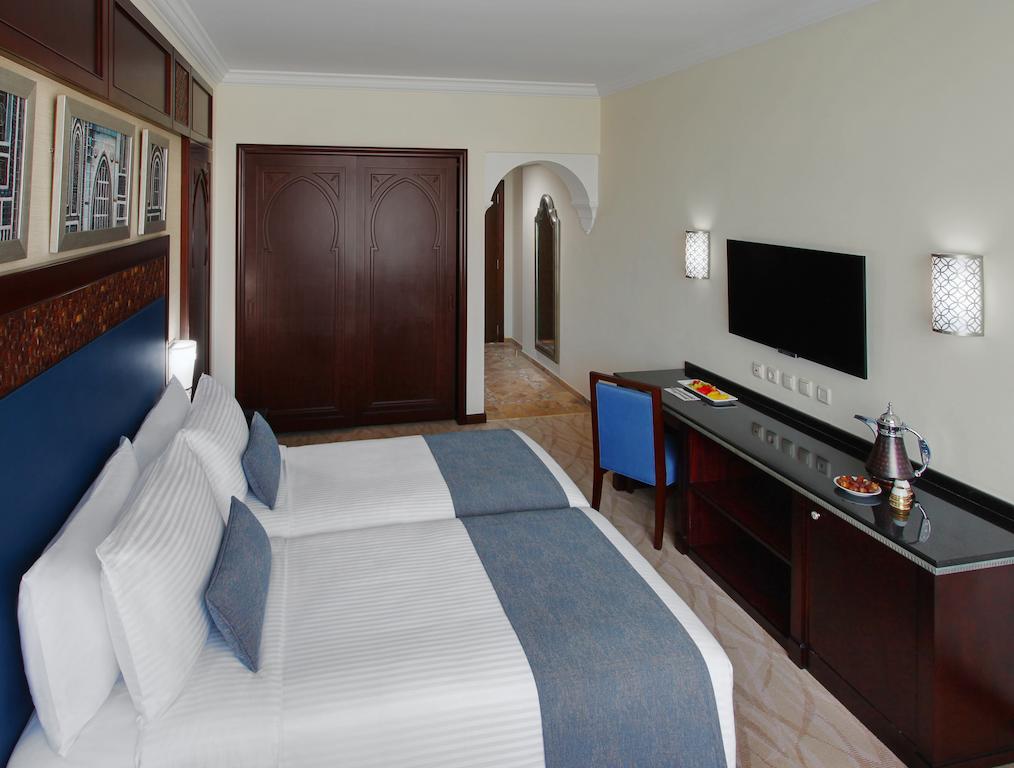 غرفة كلاسيكية بسريرين مطلة على المدينة.